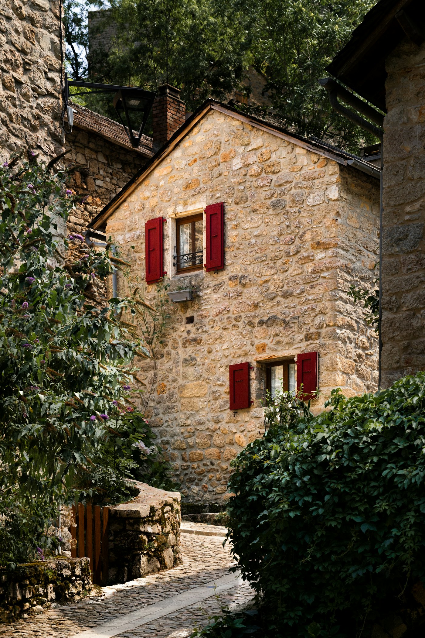 Maison en pierre aux volets rouges après restauration